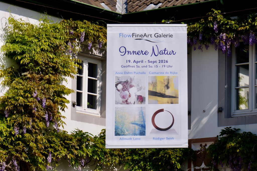 Flow Fine Art im Haus. Ein Ausstellungsbanner von Flow Fine Art in der Galerie des Yoga Hotels.
