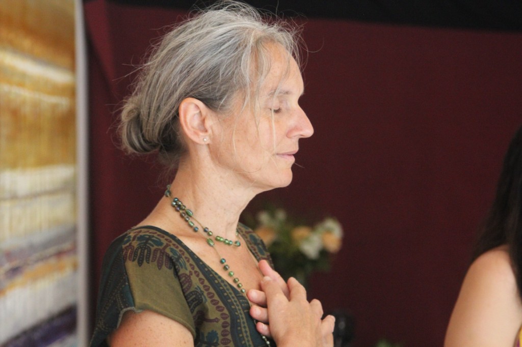 Hände am Herzen. Eine Gästin in stiller Meditation im Yoga Hotel zwischen Köln und Düsseldorf.