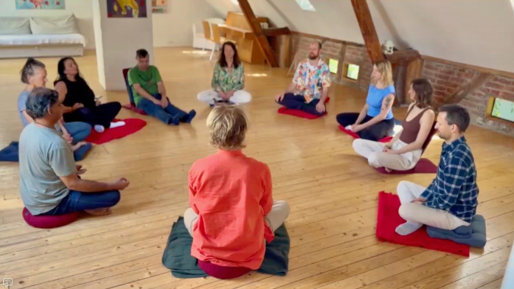 Gemeinsam im Kreis sitzen. Ein großer Meditationskreis im Dachraum des Yoga Hotels in Hitdorf, NRW.