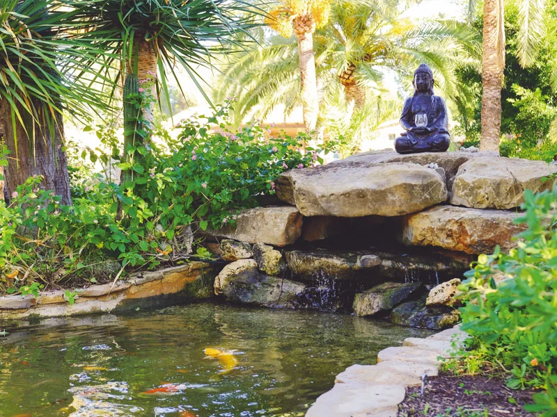 Ein Buddha am Teich im Garten der Open Sky Oasis, Dénia.